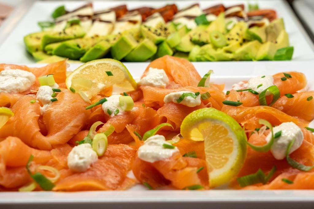 A platter of smoked salmon with lemon slices and cream cheese garnishes.