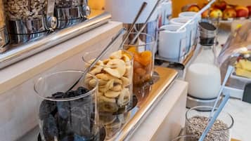 Un bufé de desayuno con diferentes alimentos y utensilios.