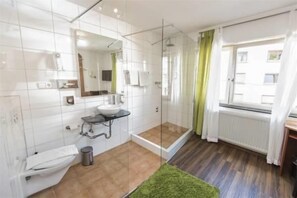 Un baño moderno con cabina de ducha de vidrio, lavamanos y retrete.