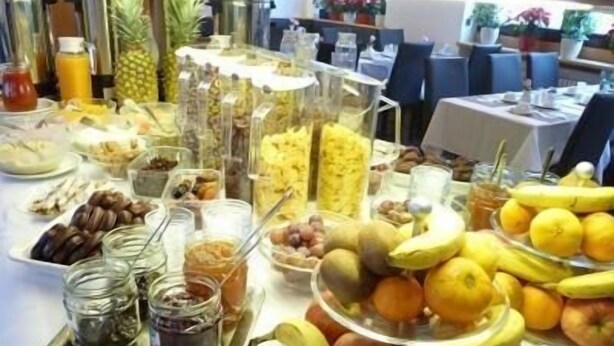 A buffet table with various fruits, nuts, and condiments.
