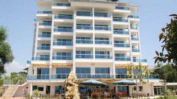 Um hotel com vários andares, um pátio central, área de estar externa e uma escultura de pedra.