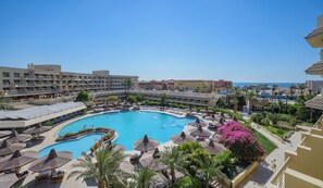 A resort with a large swimming pool, sun loungers, and a view of the ocean. - Sindbad Club (Hurghada)
