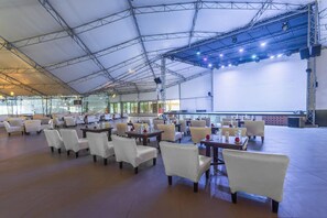 A spacious indoor venue with multiple tables and chairs arranged for dining or events. - Sindbad Club (Hurghada)