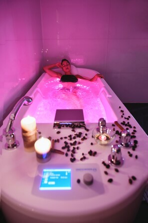 A person relaxing in a bathtub with a control panel in front of them. - Grifid Hotel Encanto Beach (Varna)