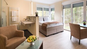 Ein modernes Schlafzimmer mit Bett, Nachttisch und Blick ins Freie.