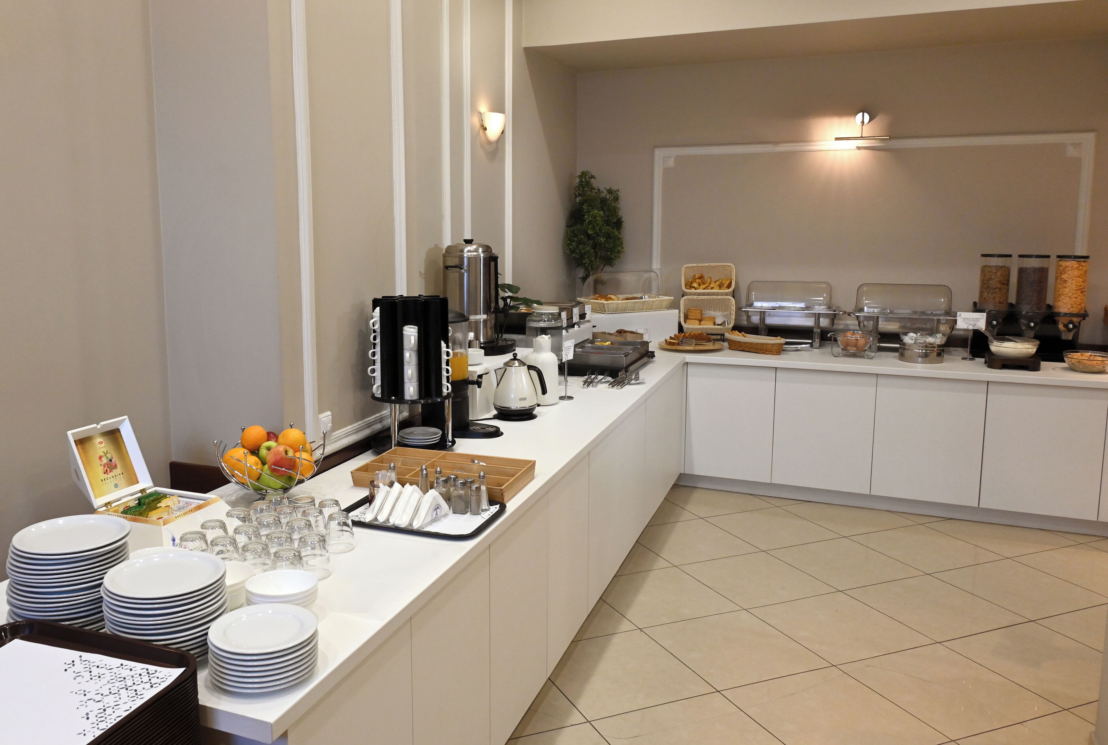 A buffet setup with various food items and serving utensils.