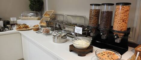 Una mesa de buffet con diversos alimentos y recipientes.