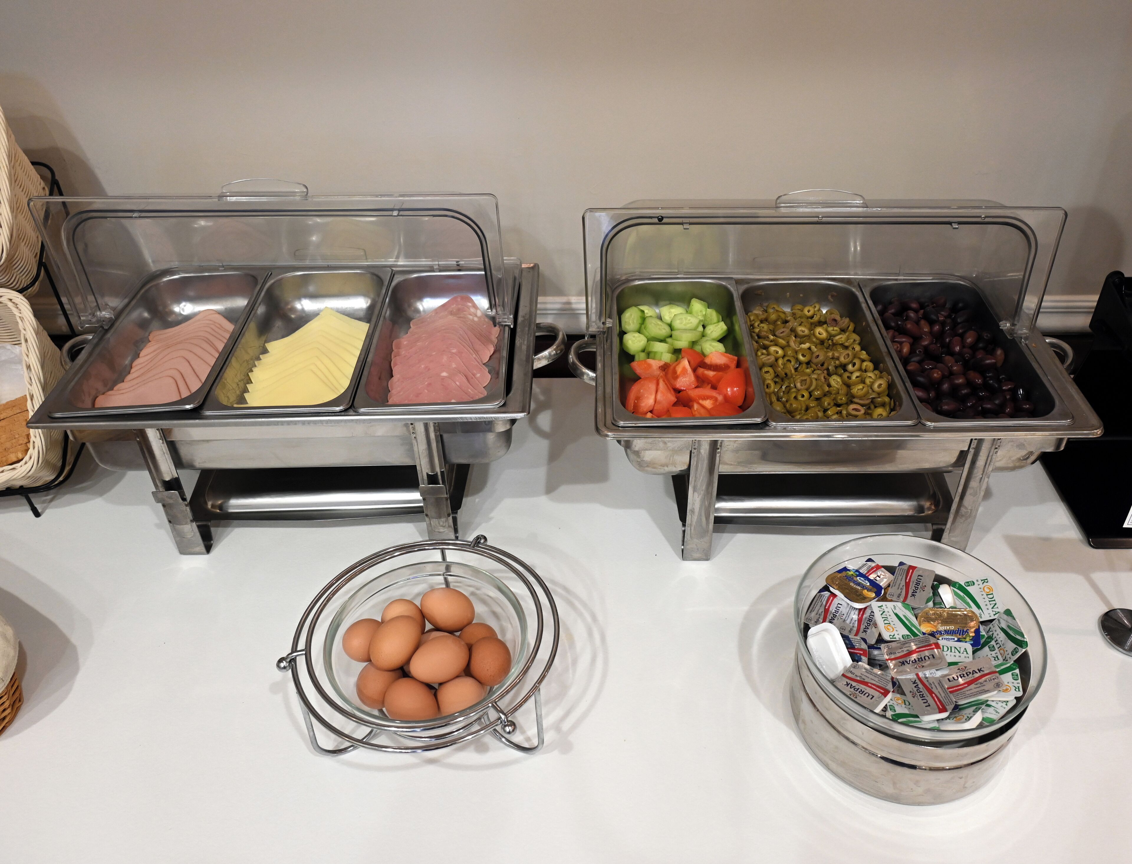 A buffet with various food items including meats, cheeses, vegetables, and eggs.