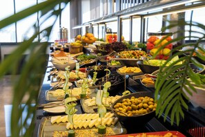 Un bufé con diversos alimentos y utensilios.