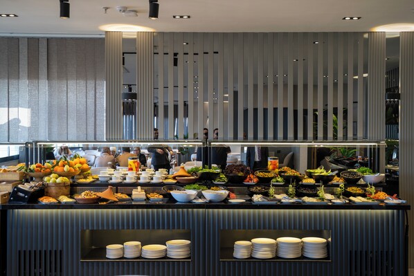 A buffet with various food items and plates arranged on a counter.