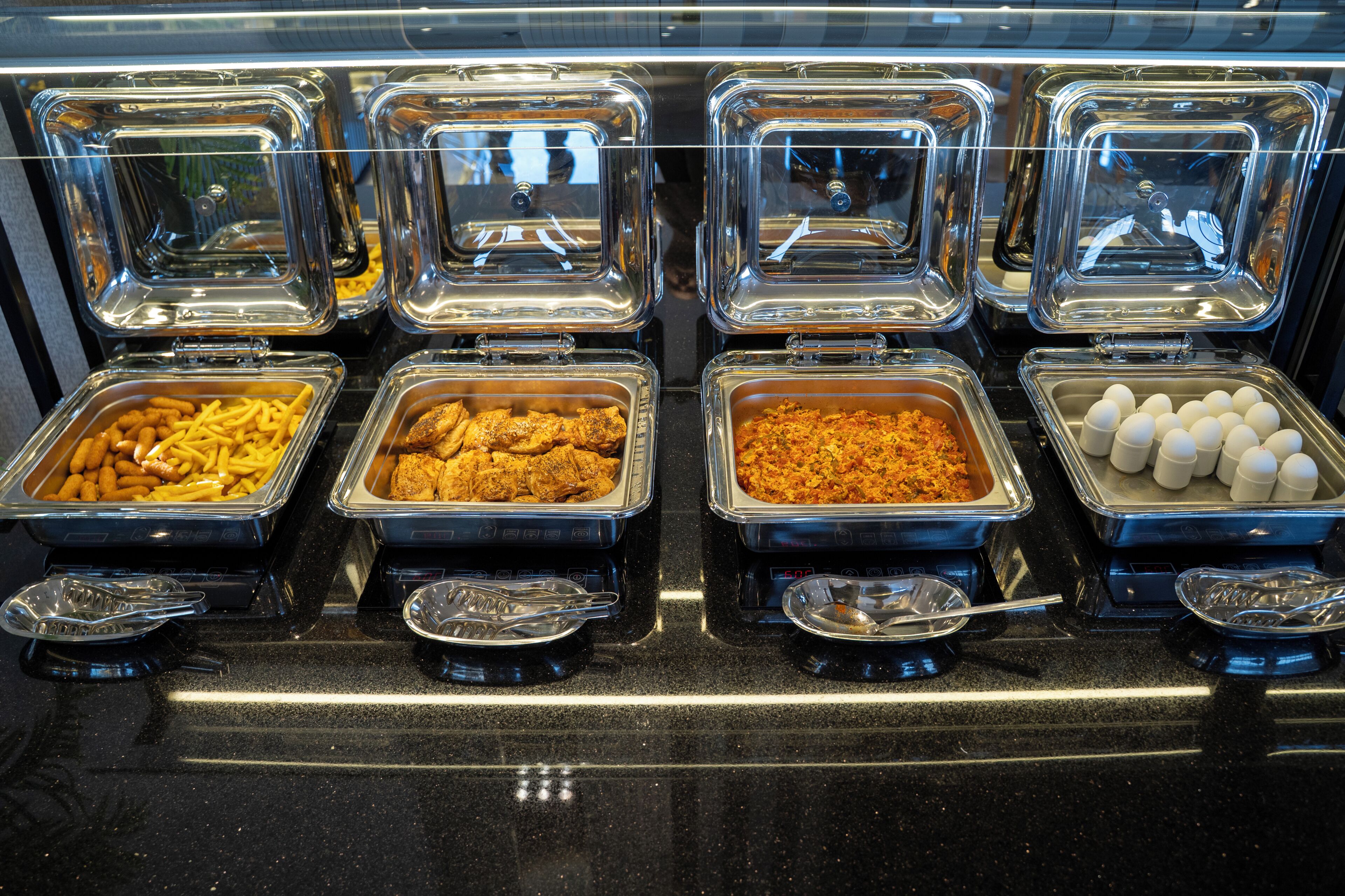 A buffet with various food items in clear containers.