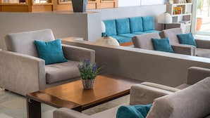 A modern living room with beige sofas, a wooden coffee table, and a blue sofa in the background. - Scaleta Beach (Rethymno)