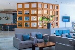 A modern lobby with a wooden partition, seating area, and a bar. - Scaleta Beach (Rethymno)
