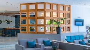 A modern lobby with a wooden partition, seating area, and a bar. - Scaleta Beach (Rethymno)