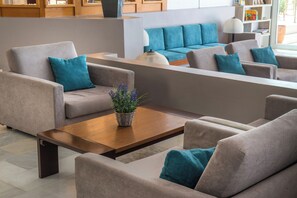 A modern living room with beige sofas, a wooden coffee table, and a blue sofa in the background. - Scaleta Beach (Rethymno)