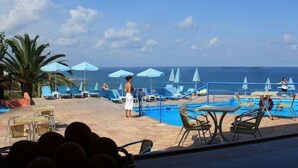A pool area with lounge chairs and umbrellas, overlooking the sea. - Scaleta Beach (Rethymno)