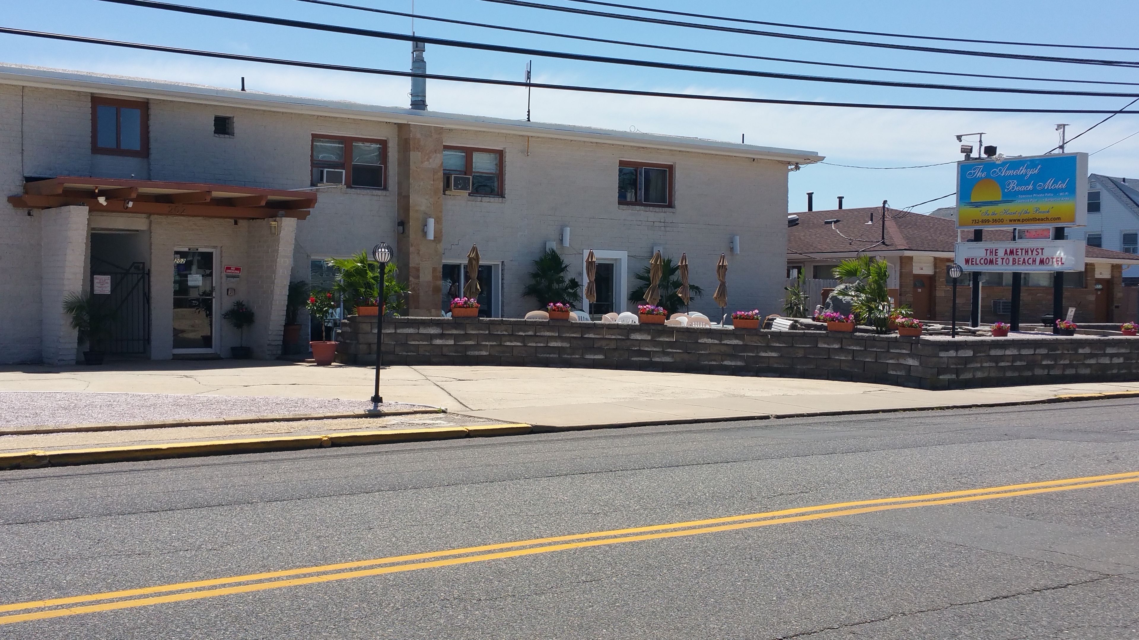 A motel with a simple facade, a front entrance, and a parking area.