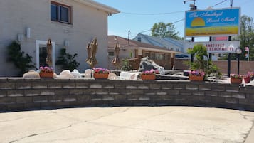 Un motel con asientos exteriores, una fuente de agua y un cartel que dice The Amethyst Beach Motel.