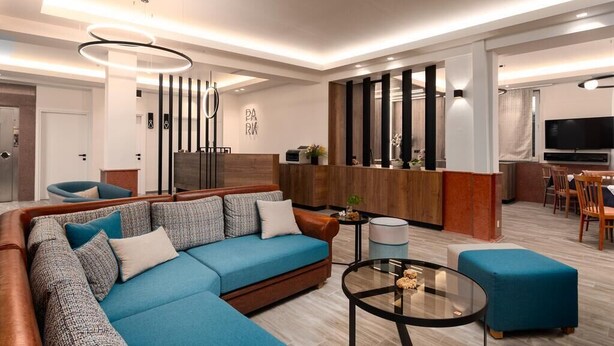 Una sala moderna con un sofá modular, una mesa de centro y una zona de cocina con barra.