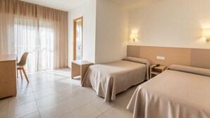 A hotel room with two beds, a desk, a chair, and a window with curtains. - Duna Hotel (Sanxenxo)