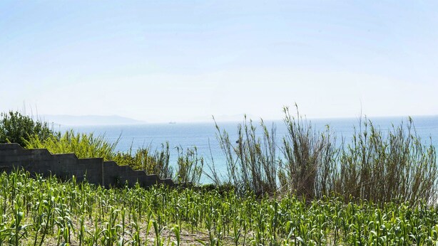 A coastal hotel with a beach view, a hill with houses, and a clear sky. - Duna Hotel (Sanxenxo)
