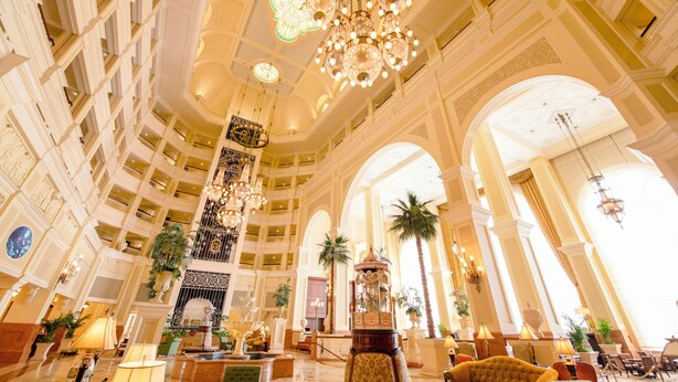A grand lobby with high ceilings, ornate chandeliers, and multiple floors.