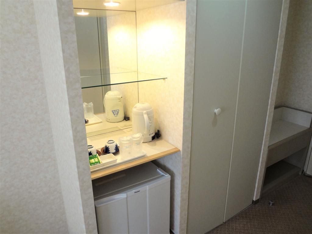 A bathroom with a glass shower enclosure, a white sink, and a mirror above it.