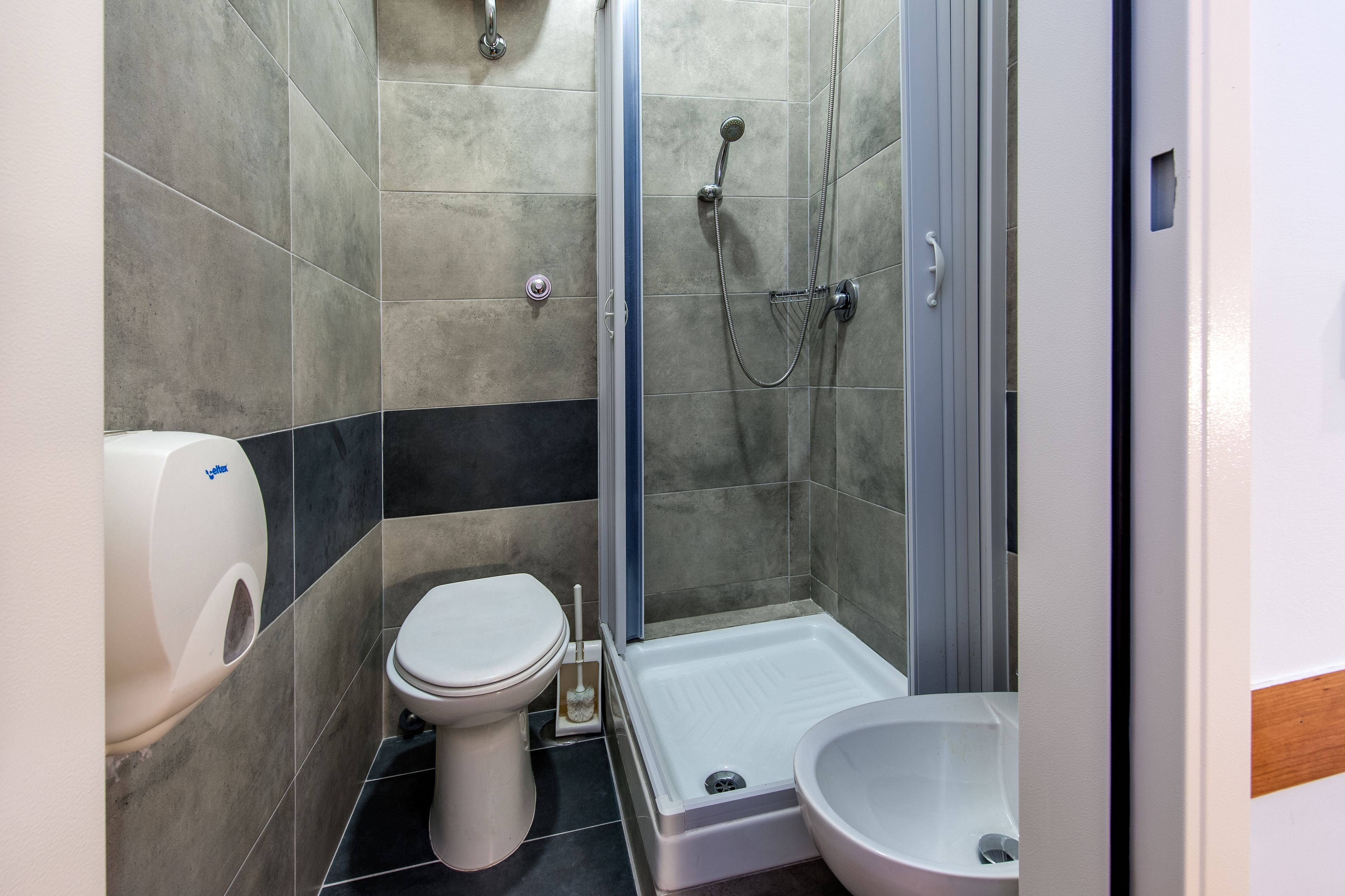 Un bagno moderno con WC, bidet e zona doccia.