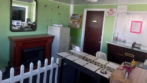 A room with a desk, a mirror, a filing cabinet, a door, and a bulletin board. - Pillow Talk Motel (Wellington)
