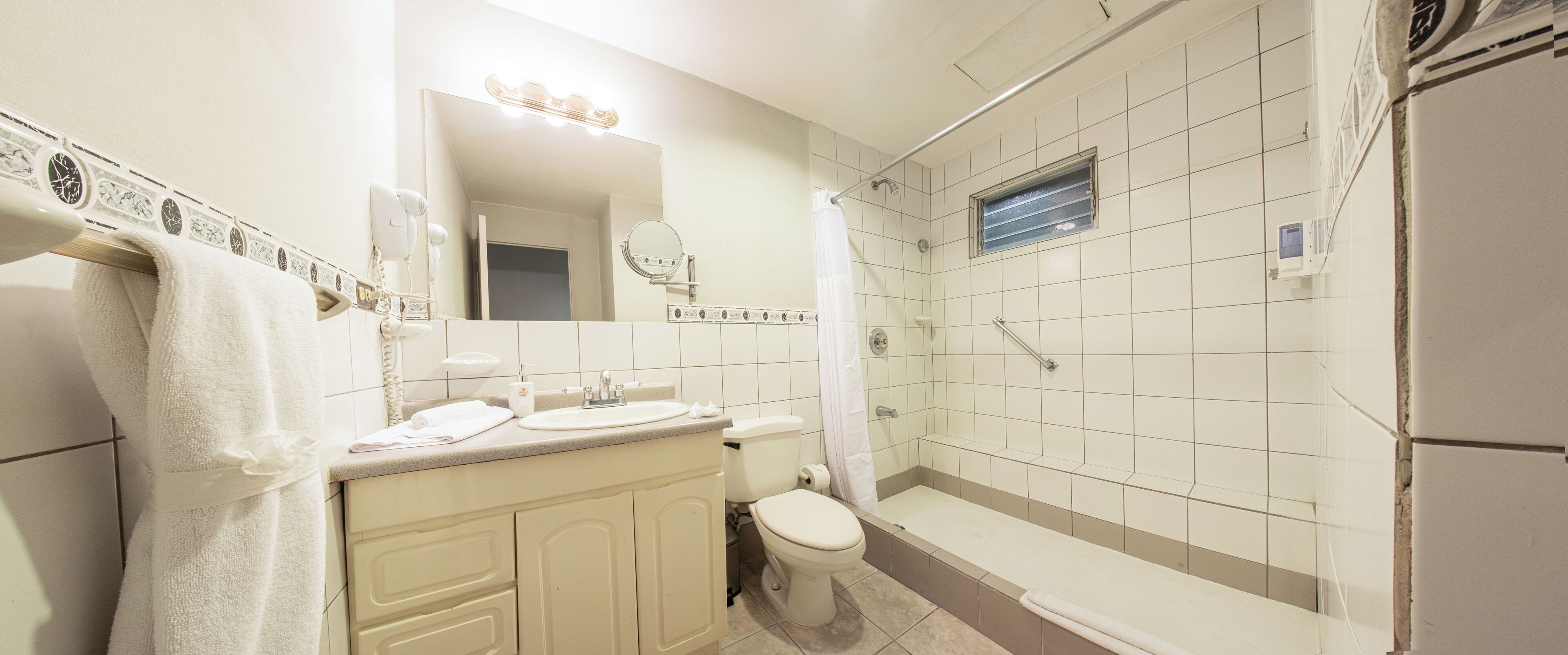 A bathroom with a sink, toilet, and shower.