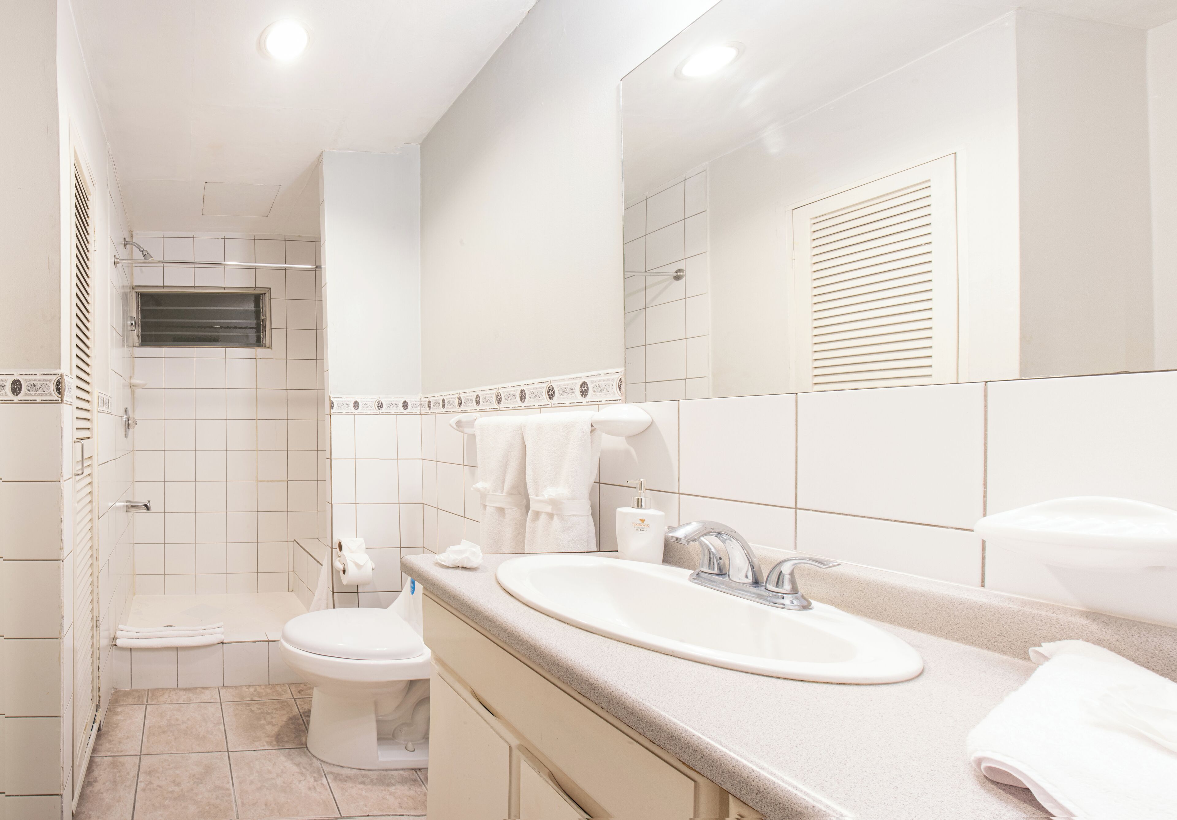 Un baño moderno con dos lavamanos, un inodoro y una ducha.