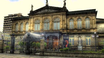 A historic building with ornate architecture, a large dome, and statues on the roof.