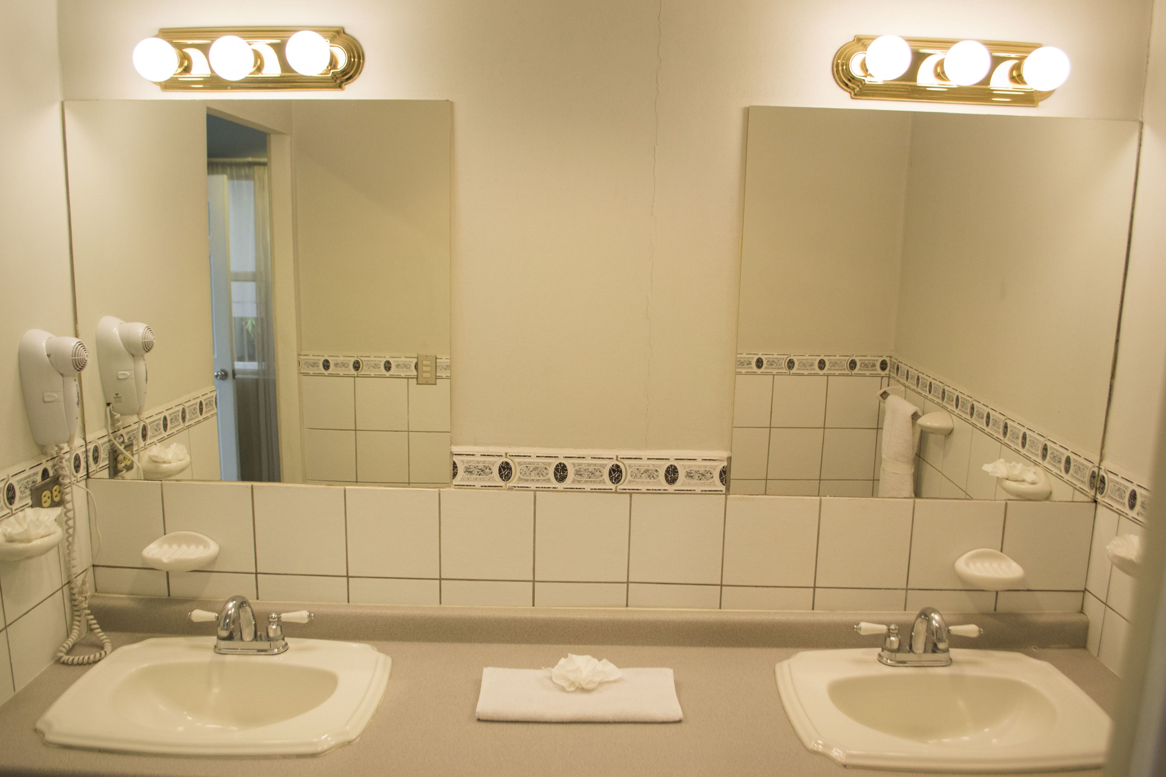 A bathroom with two sinks, a mirror, and a towel on the counter.
