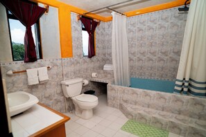 A bathroom with a toilet, sink, shower, and bathtub. - Tiosh Abaj (Santiago Atitlán)