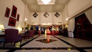 A hotel lobby with a central reflective water feature, seating areas, and framed artwork on the walls. - The Grand Hotel Nanaimo (Nanaimo)