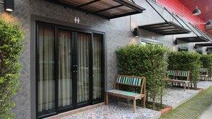 Un edificio moderno con grandes puertas de vidrio, un patio empedrado y asientos al aire libre.