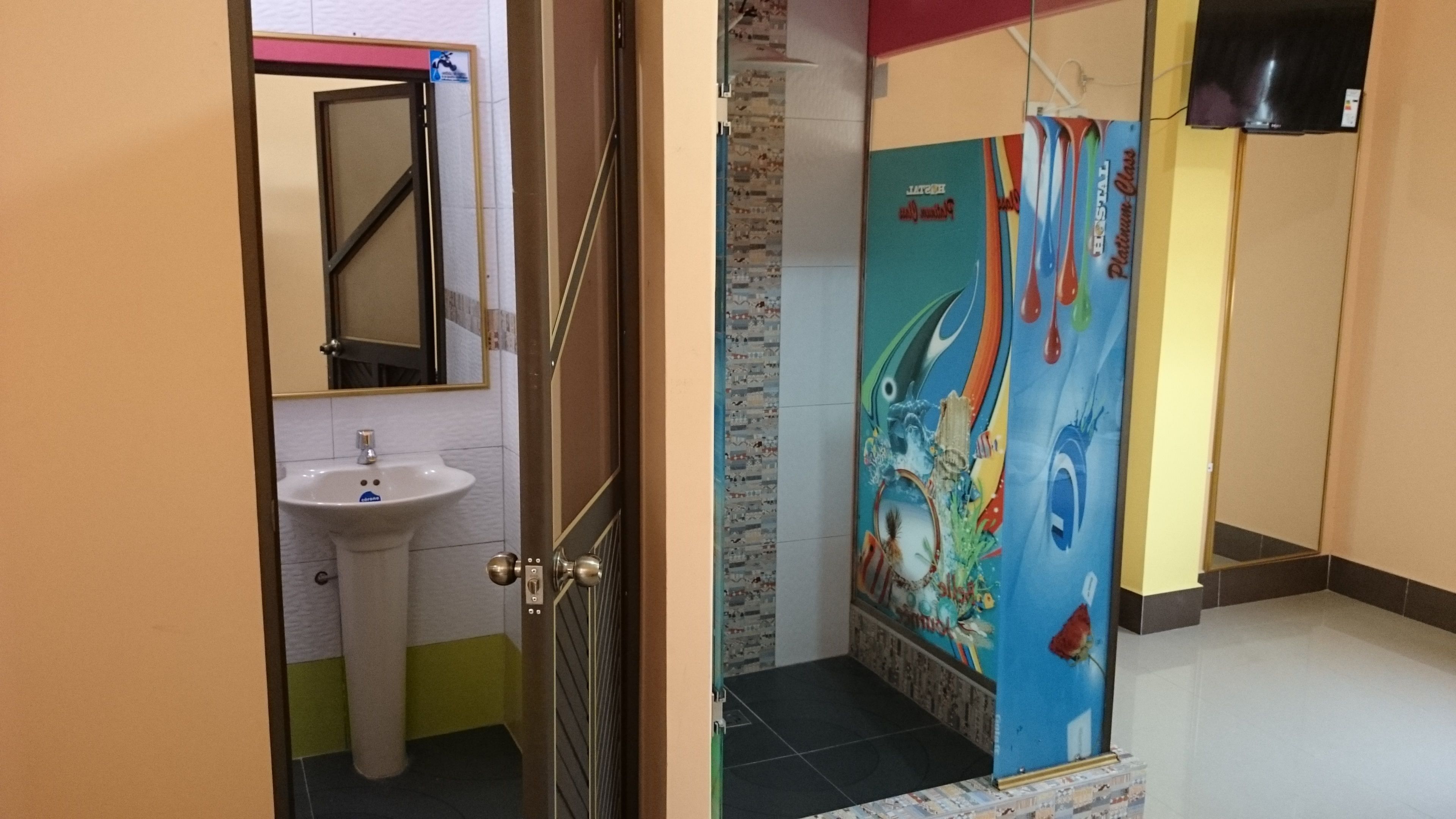 Un baño con lavamanos, espejo y una cortina de ducha colorida.