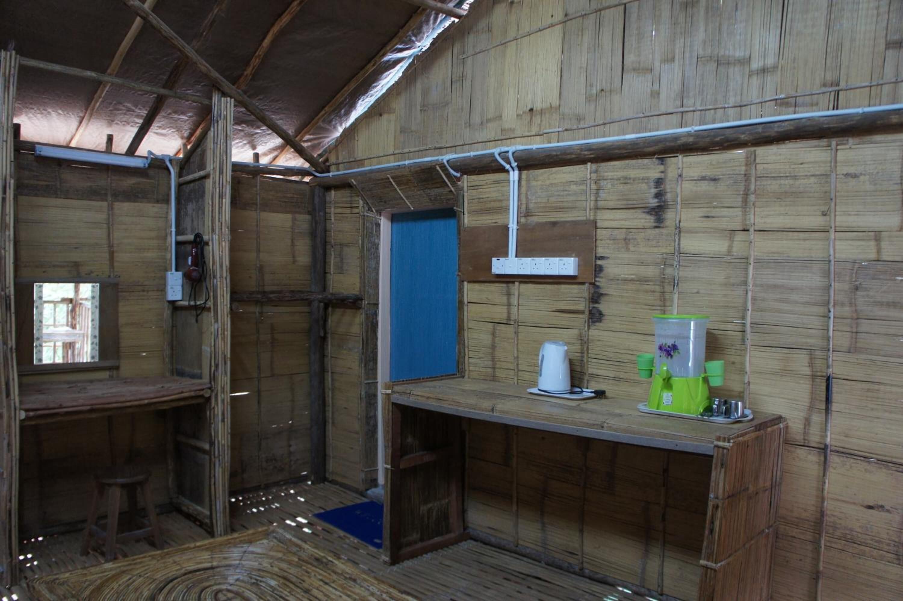 A rustic wooden room with a single table, a blue door, and a white electrical outlet.