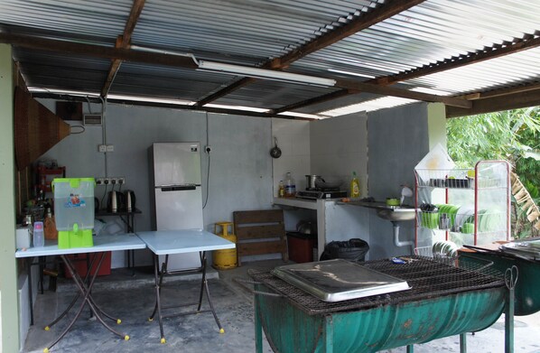 A compact kitchen with basic amenities including a refrigerator, sink, and a gas stove.