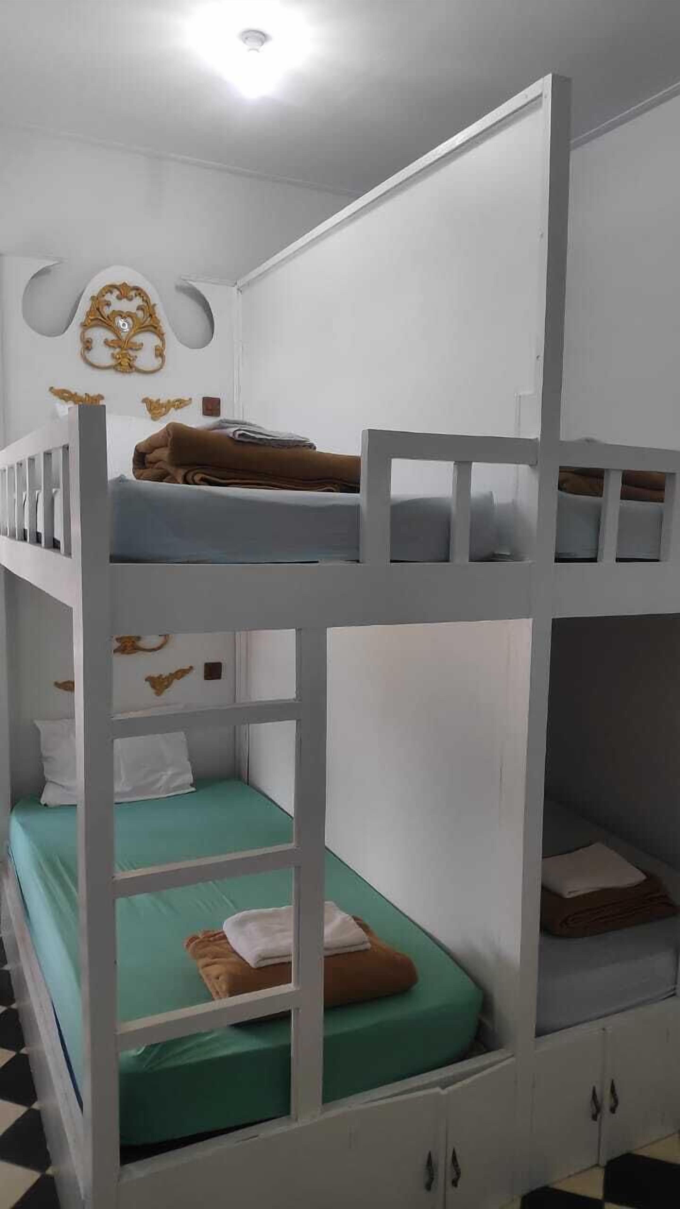 A bunk bed room with white walls and a decorative ceiling.