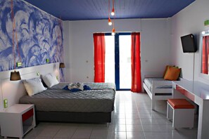 Un dormitori modern amb un llit gran, un escriptori, una cadira, un televisor i una finestra amb cortines vermelles.