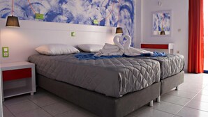Una habitación de hotel moderna con una cama grande, dos mesitas de noche y una pared con arte abstracto.