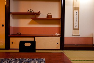 Um quarto japonês tradicional com piso de tatame, uma mesa de madeira baixa e um painel shoji.