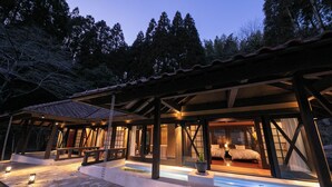 A modern, well-lit cabin with a stone-paved entrance, large windows, and a cozy interior with a bed and seating area. - Yufuin Hotel Morino Terrace (Yufu)