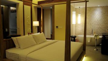 Quarto de hotel com uma cama grande, uma banheira e uma toucador com espelho.