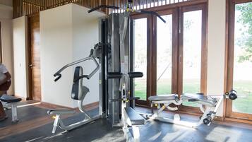 Une salle de sport équipée de matériel d’exercice, dotée de grandes fenêtres et d’un plafond en bois.