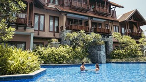 A large, multi-story hotel with a swimming pool, surrounded by lush greenery and stone structures. - Anantaya Resort and Spa Passikudah (Pasikuda)
