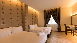 Habitación de hotel con dos camas, un escritorio y un espejo grande.
