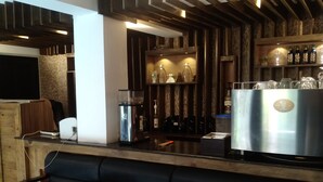 Zona de bar con mostrador, asientos y una máquina de café.