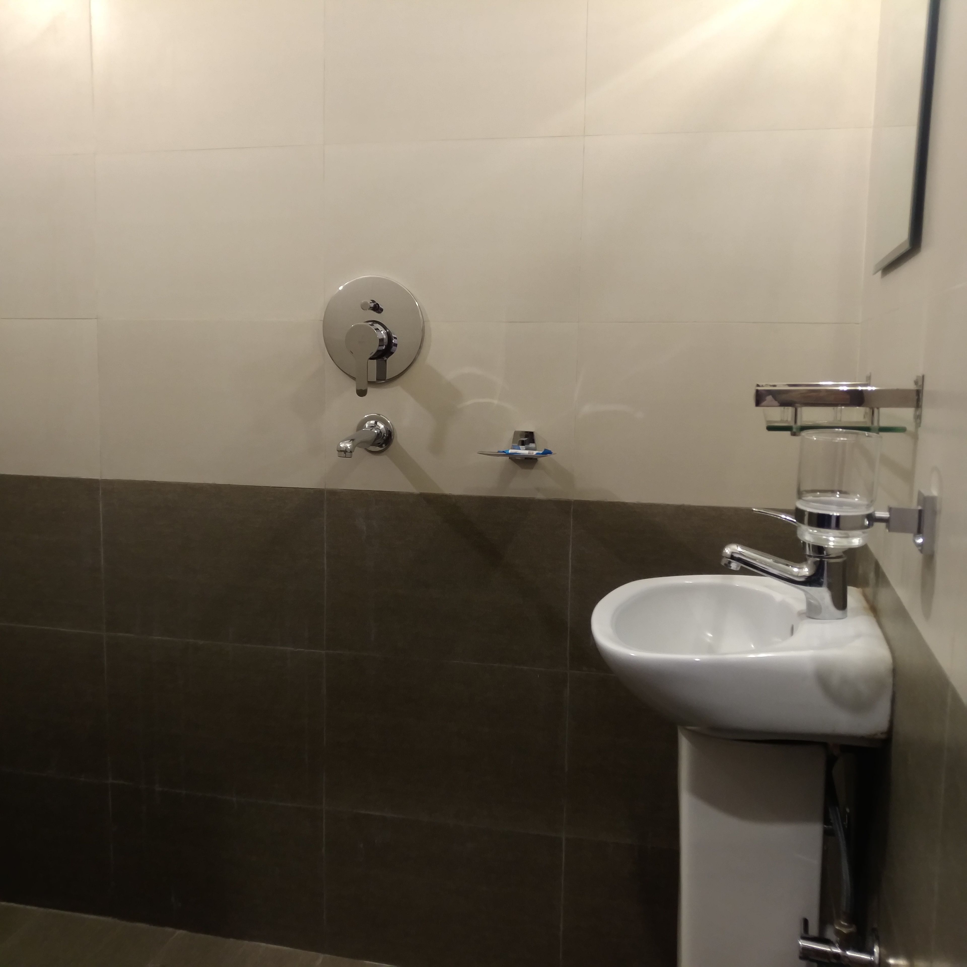 Un baño con lavabo, espejo e inodoro.